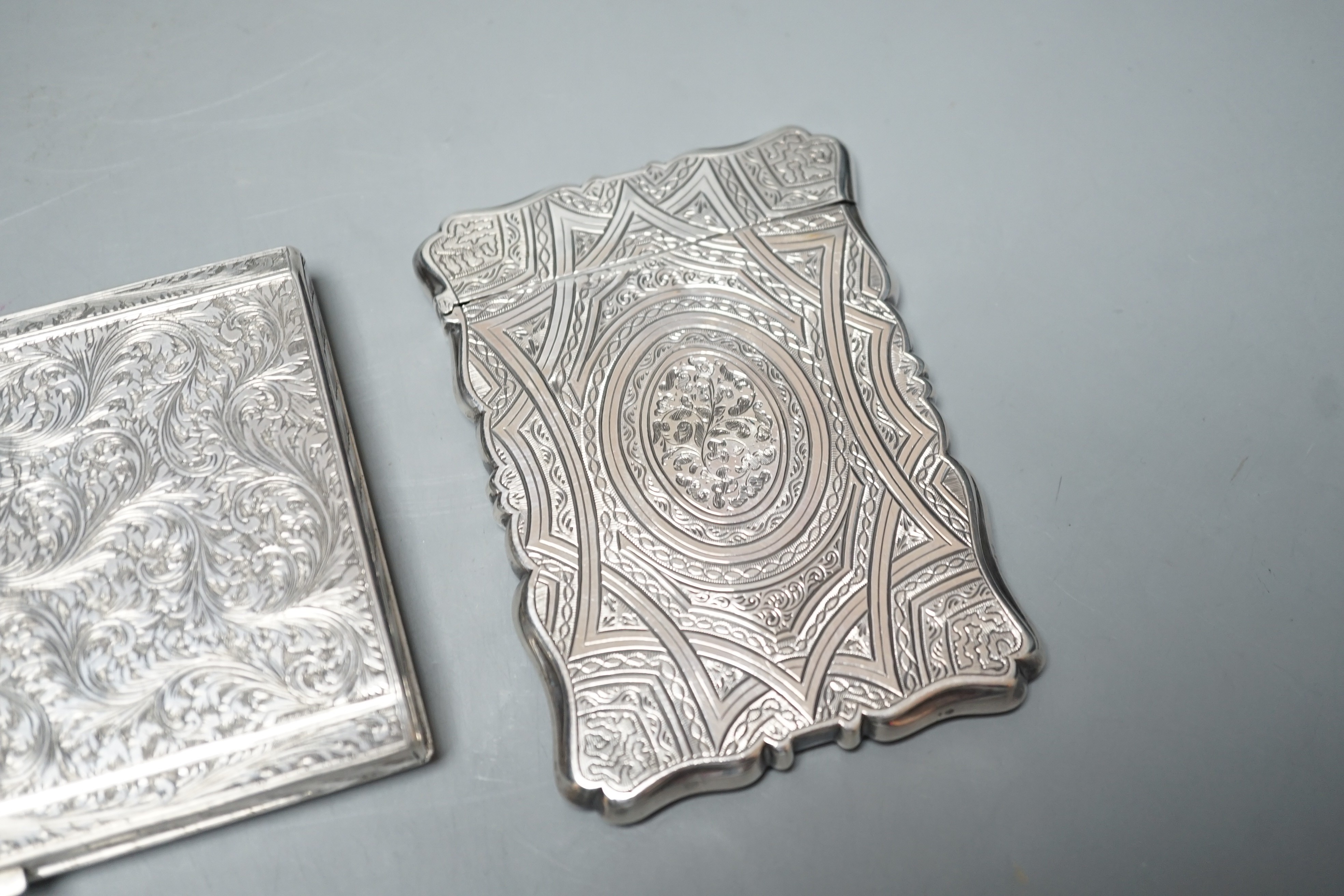 An engraved white metal card case, makers mark only AT, 97mm, together with an engraved 800 standard cigarette case, gross weight 8.9oz.